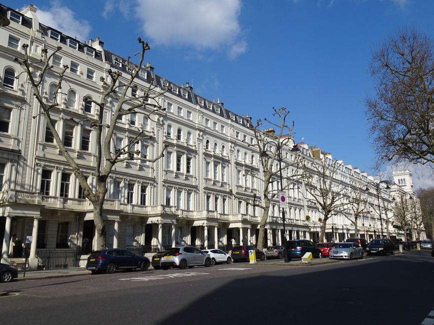 A multi-story red brick residential building in Paddington, London, featuring large sash windows, white decorative window trims, and black wrought iron balcony railings. The building's facade displays
